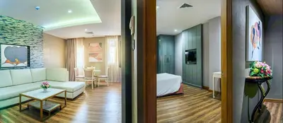 a living room with a couch and a room with a table at Royal Rattanakosin Hotel - Near Grand Palace & Khaosan Road in Bangkok
