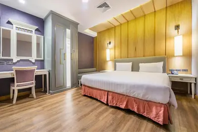 a bedroom with a large bed and a desk at Royal Rattanakosin Hotel - Near Grand Palace & Khaosan Road in Bangkok
