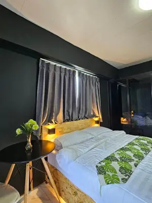 a bedroom with a bed and a table and a window at Irich Residence Theparak S407 Bts-Chang Erawan 2kms in Ban Khlong Hua Sakae