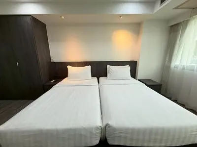 two beds in a room with white sheets at Civic Park in Bangkok