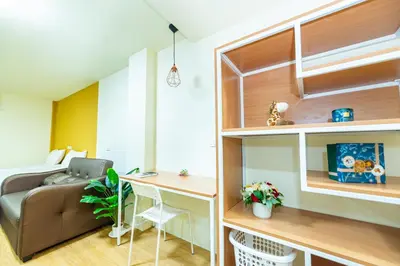 a small living room with a couch and a desk at GL Sport Club Serviced Residence in Bangkok