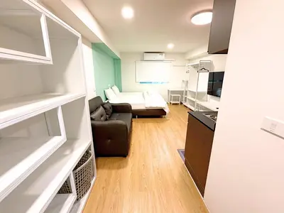 a small room with a couch and a bed at GL Sport Club Serviced Residence in Bangkok