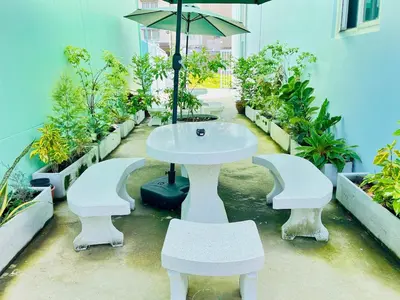 a white table and chairs with an umbrella and plants at Setthisin Art Boutique House,Iconsiam,BTS Thonburi in Godown