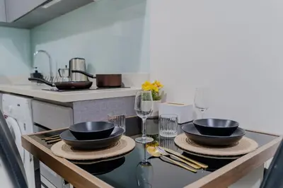 a kitchen with two bowls and wine glasses on a table at 5 Star Sukhumvit Condo Infinity Pool Gym Sauna in Bangkok