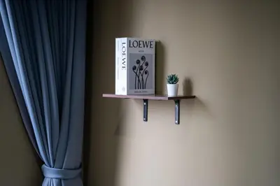 a book sitting on a shelf next to a curtain at 5 Star Sukhumvit Condo Infinity Pool Gym Sauna in Bangkok