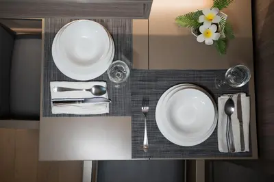 a table with white plates and silverware on a shelf at 5 star Luxurious 1BD apt King Bed Thong Lor in Bangkok