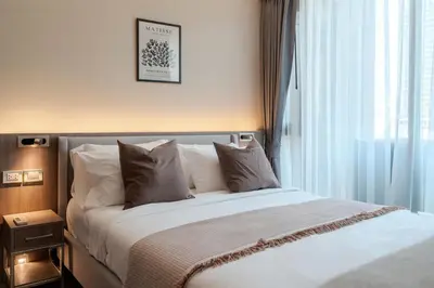a bedroom with a white bed with a window at Luxury 2BR with Sky Pool & Gym Near BTS Thong lo in Bangkok