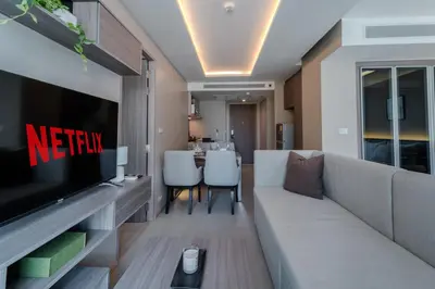 a living room with a couch and a television at Luxury 2BR with Sky Pool & Gym Near BTS Thong lo in Bangkok