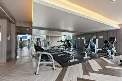 a gym with several treadmills and machines in a room at Luxury 2BR with Sky Pool & Gym Near BTS Thong lo in Bangkok
