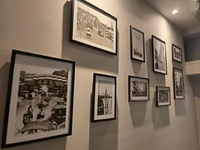 a wall with framed pictures on a wall at Lhong Krung Hostel in Bangkok