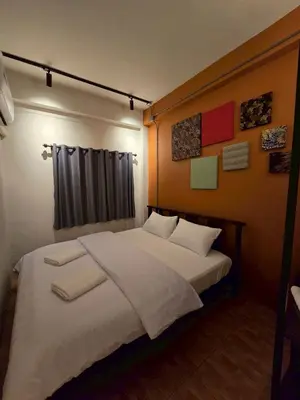 a bedroom with a large bed with white sheets at Lhong Krung Hostel in Bangkok