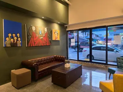a living room with a leather couch and a window at Lhong Krung Hostel in Bangkok