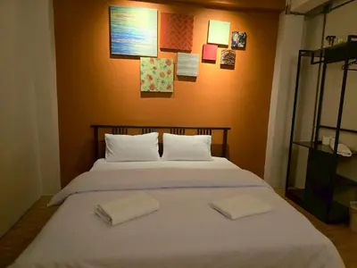 a bedroom with a bed with two towels on it at Lhong Krung Hostel in Bangkok