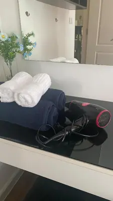 a counter with towels and a racket and a mirror at Cozy Entire Apartment place in Ban Khlong Samrong