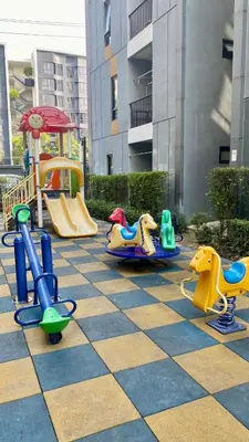 a playground with a slide and rides on a checkered floor at Cozy Entire Apartment place in Ban Khlong Samrong