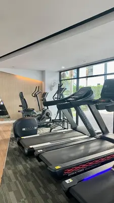 a gym with several treadmills and exercise bikes at Cozy Entire Apartment place in Ban Khlong Samrong