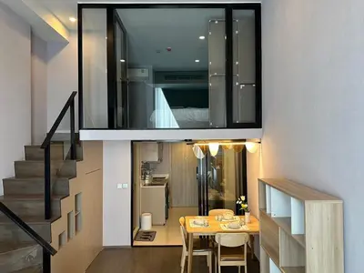 a room with a dining room table and a staircase at Standardized at City View Condo near BTS Ratchathewi in Bangkok
