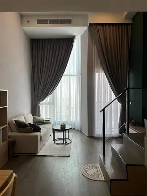 a living room with a couch and a large window at Standardized at City View Condo near BTS Ratchathewi in Bangkok