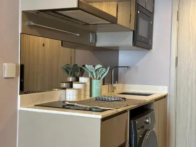 a kitchen with a stove top oven next to a sink at Standardized at City View Condo near BTS Ratchathewi in Bangkok