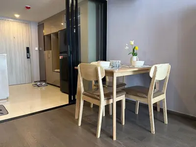 a dining room table with two chairs and a kitchen at Standardized at City View Condo near BTS Ratchathewi in Bangkok