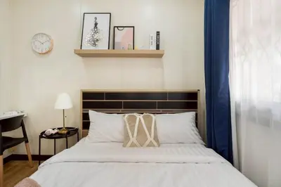 a bedroom with a bed and a clock on the wall at GM7 - Private House Downtown 2mins walk to metro in Bangkok