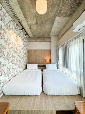 two beds sitting next to each other in a room at Nara Poshtel Sathorn in Bangkok