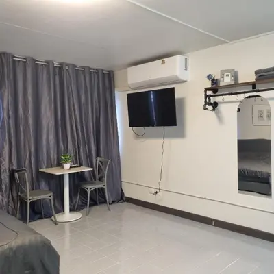 a room with a table and a tv on the wall at Popular Muang Thong Condo, Building T9, Floor 8, Room 20 in Ban Bang Phang