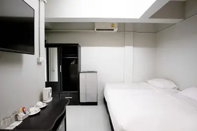 a small room with a bed and a television at Annex Lumpini Bangkok in Bangkok