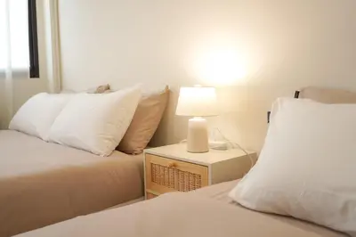 a bedroom with two beds and a lamp on a night stand at Buddy House in Chinatown - Private Rooms Walk to MRT in Bangkok