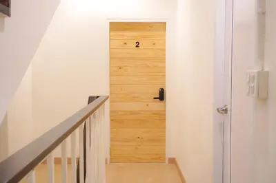 a hallway with a wooden door in a house at Buddy House in Chinatown - Private Rooms Walk to MRT in Bangkok
