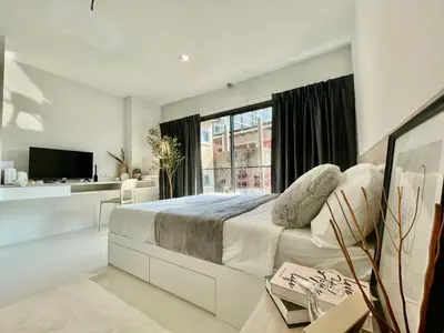 a white bedroom with a large bed and a window at Cozy Stay! Near Chatuchak Market 816 in Bangkok