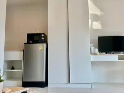a refrigerator with a microwave on top of it at Cozy Stay! Near Chatuchak Market 816 in Bangkok