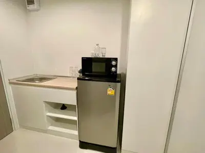 a small kitchen with a microwave on top of a refrigerator at Cozy Stay! Near Chatuchak Market 816 in Bangkok