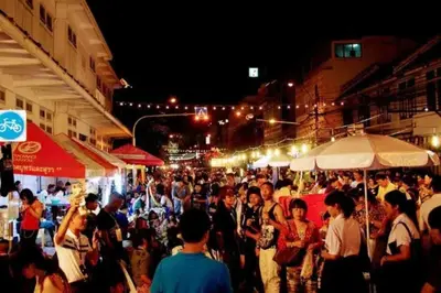 a crowd of people walking through a market at night at Diamond House Khaosan in Bangkok