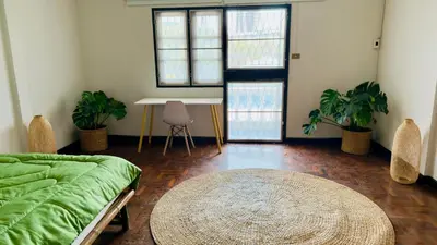 a room with a bed and a table and windows at Creative Bangkok Balcony in Sathani Bang Khen
