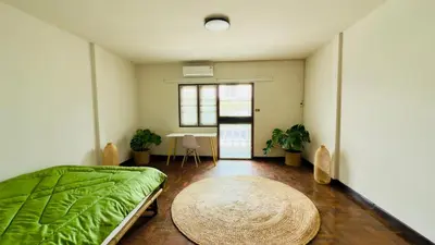 a bedroom with a bed and a table in it at Creative Bangkok Balcony in Sathani Bang Khen
