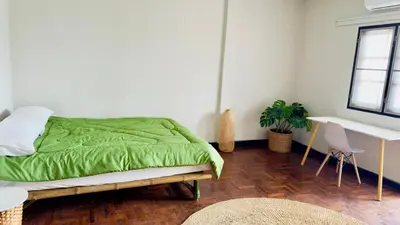 a bedroom with a green bed and a desk at Creative Bangkok Balcony in Sathani Bang Khen
