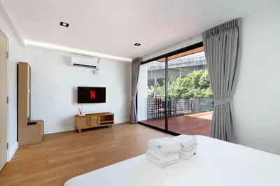 a bedroom with a bed and a large window at Townhouse in Khet Phayathai - Ari in Bangkok