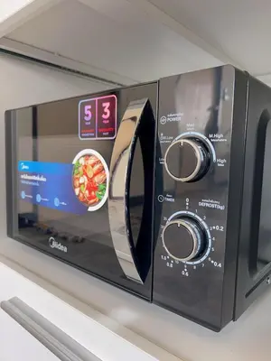 a microwave oven on a shelf with a bowl of food at 55sqm Hispeed LAN WiFi workplace 24h maxvalu in Bangkok