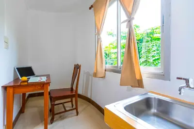 a kitchen with a sink and a table and a chair at Dancenter Howard Square Boutique Hotel in Bangkok