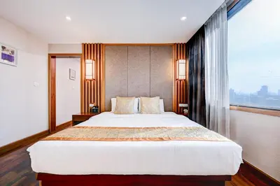 a bedroom with a large bed and a large window at Dancenter Bangkok Travellers Hotel in Bangkok
