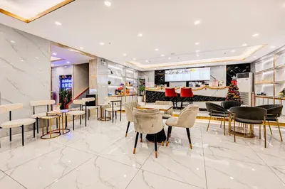 a lobby with tables and chairs and a christmas tree at Dancenter Bangkok Travellers Hotel in Bangkok