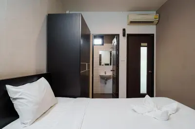 a bedroom with a white bed and a bathroom at Dancenter Khaosan Park Hotel in Bangkok