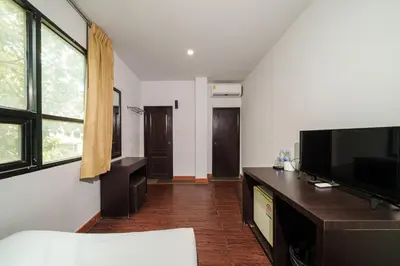 a living room with a flat screen tv and a table at Dancenter Khaosan Park Hotel in Bangkok