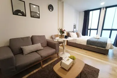 a living room with a couch and a bed at Amazing 1 bedroom 2 mins walk BTS On Nut in Bangkok