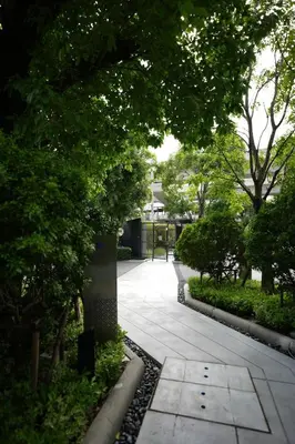 a walkway in a park with trees and a fence at Life Ladprao 2 bedrooms condo in Bangkok