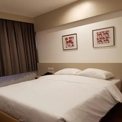 a bedroom with a large white bed with two pillows at Florida Hotel in Bangkok