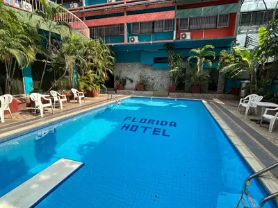 a swimming pool with a hotel sign next to a building at Florida Hotel in Bangkok