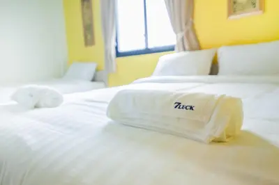 a white bed with a hotel towel on it at The Seven Luck in Bangkok