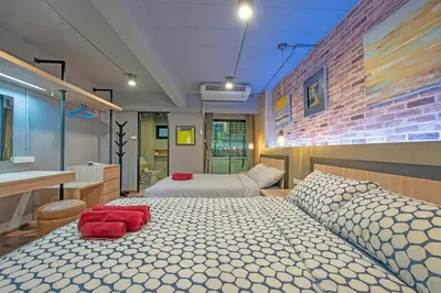 a bedroom with two beds and a brick wall at Private apartment in Huaikwang in Bangkok